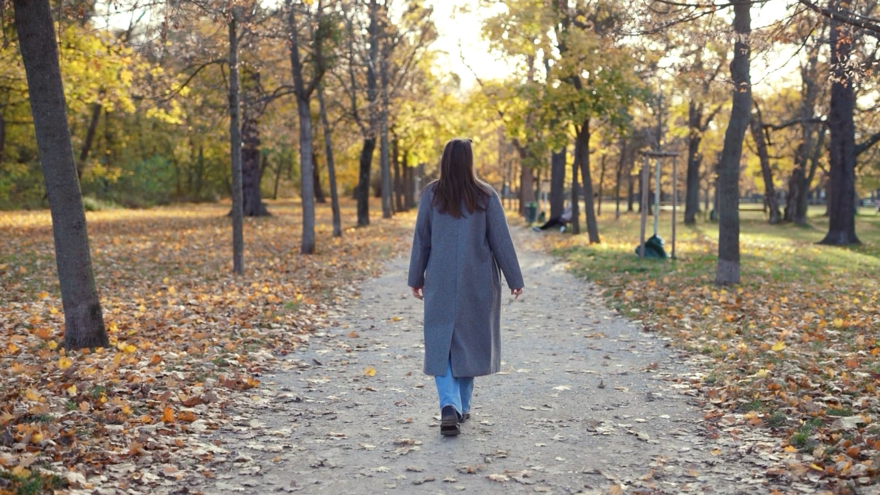 Mentaltrainerin Alina Marie Fraissl spaziert durch einen herbstlichen Park in Wien – Fokus auf persönliches Wachstum und Mentaltraining.